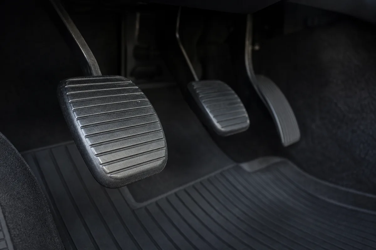 Pédalier d&rsquo;une voiture vu de près depuis le plancher, pédale d&rsquo;embrayage à gauche